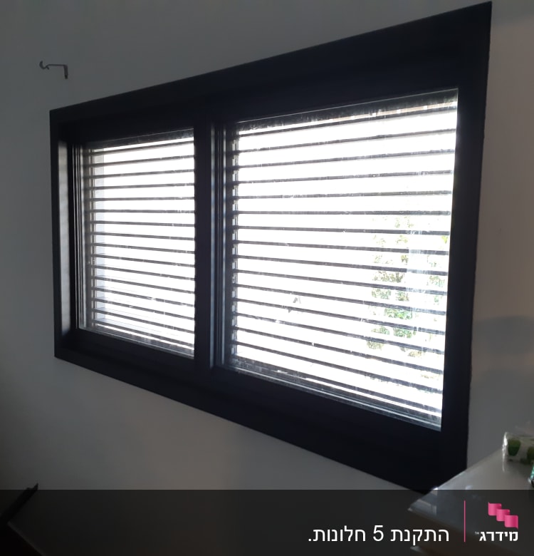 חלון עם תריסי אלומיניום סגורים